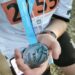 Nahaufnahme einer hellblauen Medaille des 15. Citylaufs Leonberg 2025, die von einer Person in einem Laufshirt mit Startnummer 2455 gehalten wird.
